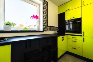 トルクミツコにあるApartament u Rudejの黄色のキャビネットと窓付きのキッチン