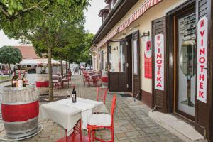 una mesa y sillas sentadas fuera de un restaurante en Riviéra Rooms Vendégszobák, en Mosonmagyaróvár