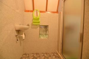 a bathroom with a sink and a shower with a mirror at Bale Baleku Homestay in Praya