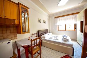 a room with a bed and a table and a kitchen at THE OLD TOWN CLOCK in Gjirokastër