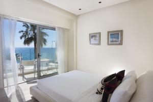 a bedroom with a bed and a view of the ocean at Elite City Resort in Kalamata