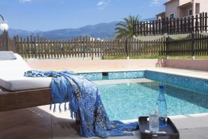 a swimming pool with a bed and a bottle of water at Elite City Resort in Kalamata