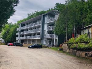 a large apartment building on the side of a dirt road at Tremblant Studio Kona by My Tremblant Location in Mont-Tremblant