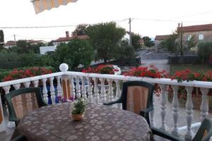 a table and chairs on a balcony with flowers at Apartments Nella in Sveti Anton