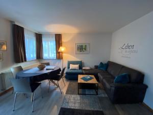 a living room with a couch and a table at Aktiv- und Wellnesshotel Gutjahr in Abtenau