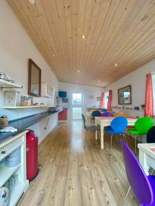 Il comprend une cuisine avec des plafonds en bois, une table et des chaises. dans l'établissement Oasen, à Viborg