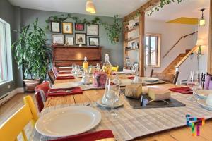 uma sala de jantar com uma mesa de madeira com cadeiras e uma mesa; em Almatoit em Alma