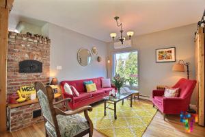 a living room with red furniture and a brick fireplace at Almatoit in Alma