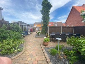 a patio with a table and chairs in a garden at Oasen in Viborg