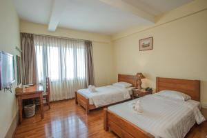 מיטה או מיטות בחדר ב-Shwe Ingyinn Hotel Mandalay