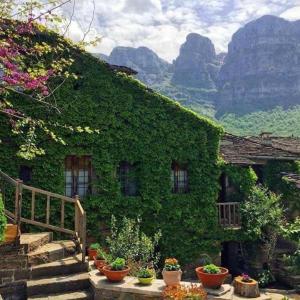 Saxonis Houses & Saxonis Villa في بايبيغكو: منزل مغطى بالحلوى مع السلالم والنباتات الفخارية