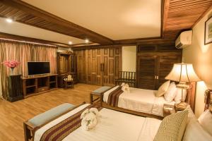 pokój hotelowy z 2 łóżkami i telewizorem w obiekcie Shwe Ingyinn Hotel Mandalay w mieście Mandalaj