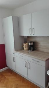 a kitchen with white cabinets and a coffee maker on the counter at Ferienwohnung Madlene 1 in Gablitz