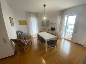 sala de estar con mesa de comedor y sillas en Condominio Aquilone, en Lignano Sabbiadoro
