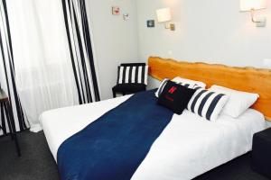 a hotel room with a bed with a blue blanket at Hotel de la Placette Barcelonnette in Barcelonnette