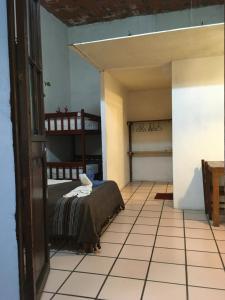 a bedroom with a bed and a tiled floor at Hostal Luz de Luna Nuyoo in Oaxaca City