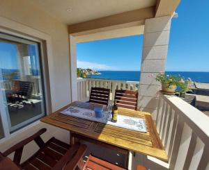 a table on a balcony with a view of the ocean at Apartments Tanja in Zavalatica