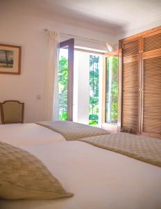1 dormitorio con 2 camas y ventana abierta en Villa Altozano with pool, barbeque, large garden, and fantastic sea views, en Benidorm