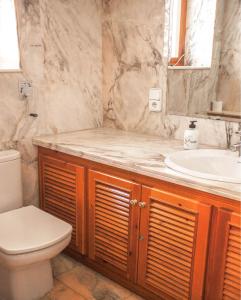 a bathroom with a sink and a toilet at Villa Altozano with pool, barbeque, large garden, and fantastic sea views in Benidorm