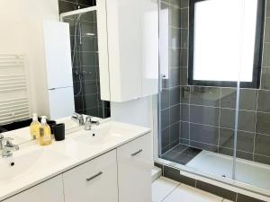 Un baño blanco con dos lavabos y una ducha. en RESIDENCE 7 maison mitoyenne moderne quartier aiguillon, en Arcachon 7 fotos más