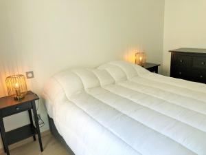una camera da letto con un grande letto bianco con due comodini di RESIDENCE 7 maison mitoyenne moderne quartier aiguillon ad Arcachon