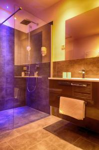 ein großes Bad mit einer Dusche und einem Waschbecken in der Unterkunft Aktiv- und Wellnesshotel Gutjahr in Abtenau
