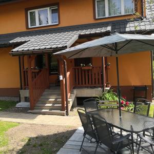 stół z parasolką przed domem w obiekcie Apartament Na Rozdrożu w Cisnej