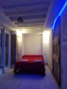 1 dormitorio con 1 cama roja con luz azul en the secret garden in the very heart of Venice, en Venecia