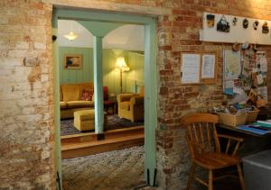 a room with a living room with a chair and a mirror at Brackenborough Hall Coach House - Saddle Room in Louth