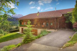 a large wooden house with a driveway at Chalet L'Otavalo - OVO Network in Manigod