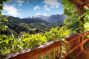 a wooden balcony with a view of mountains at Chalet L'Otavalo - OVO Network in Manigod +16 photos