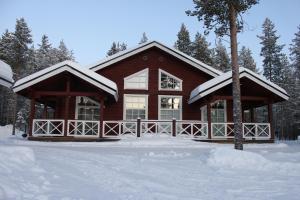 a log cabin in the snow with snow on it at Levi Unelma Villa in Levi