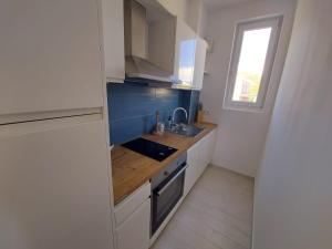 a small kitchen with a sink and a window at Apartments Tanja in Zavalatica