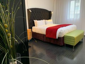 een hotelkamer met een bed en een groene stoel bij Hotel Chez Swann in Montreal