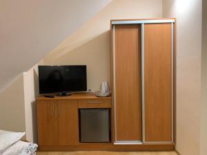een kamer met een tv en een houten kast met een televisie bij Pokoje gościnne Hania in Karwia