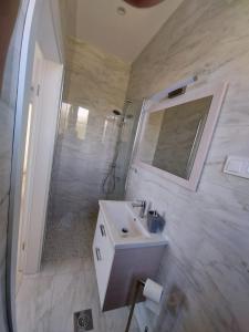 a bathroom with a sink and a shower with a mirror at Apartments Tanja in Zavalatica