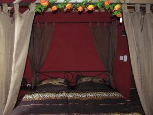 a bed with a red head board with flowers above it at HummelCasa Ferienhaus Bayreuth in Pittersdorf