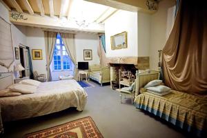 duża sypialnia z 2 łóżkami i kominkiem w obiekcie Château Du Bois Glaume w mieście Poligné