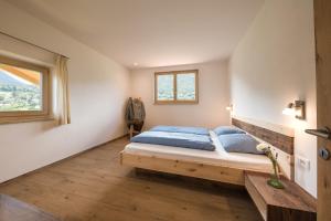 Schlafzimmer mit einem Bett und einem Fenster in der Unterkunft Steinkellerhof in Völlan