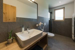 ein Badezimmer mit einem weißen Waschbecken und einer Toilette in der Unterkunft Steinkellerhof in Völlan + 31 Fotos