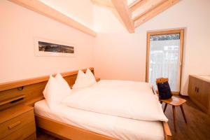 a bedroom with a white bed and a window at App. Erta - Ciasa Lavarella in San Vigilio Di Marebbe