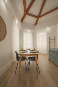 - une salle à manger avec une table et des chaises en bois dans l'établissement Vibrant Porto Apartments - Heroismo's Metro, à Porto