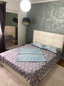 a bedroom with a bed with a blue comforter at Apartament Faleza Nord 3 in Constanţa