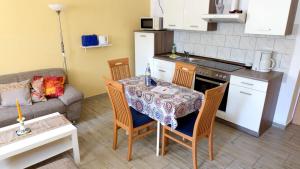 a living room with a table and chairs and a kitchen at Sylvias Ferienwohnung Nr6 souterrain in Görlitz