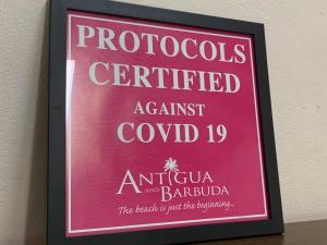 a sign on a wall that reads protocols certified against cornell at Buccaneer Beach Club in Dickenson Bay