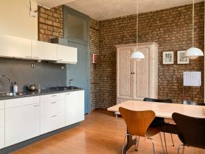 a kitchen with white cabinets and a wooden table at Besselaar Apartments in Maastricht
