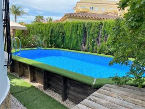 a swimming pool in a yard next to a fence at Family Beach Villa Rubens in Oliva