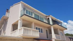 a house with a balcony on top of it at Apartments Tanja in Zavalatica