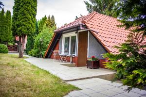 a house with a red roof with a patio at Apartamenty Szkocka in Gdańsk