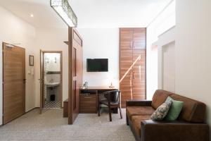 a living room with a couch and a desk at Penzion Troja in Lipany